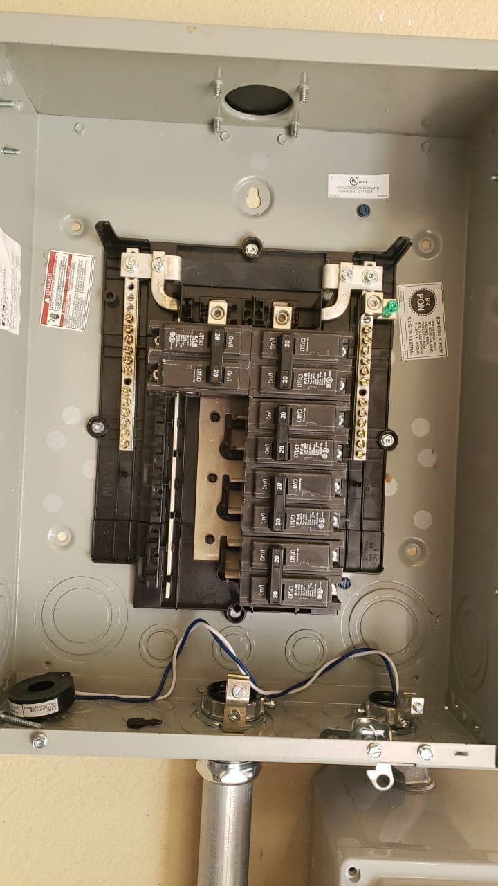 Image of an electrical panel with multiple circuit breakers and wiring connections.